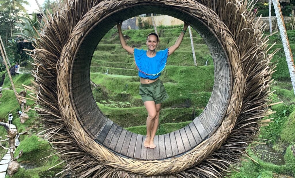 Dr. Natalia Wiechowski steht in einem großen, geflochtenen Rad auf Bali.