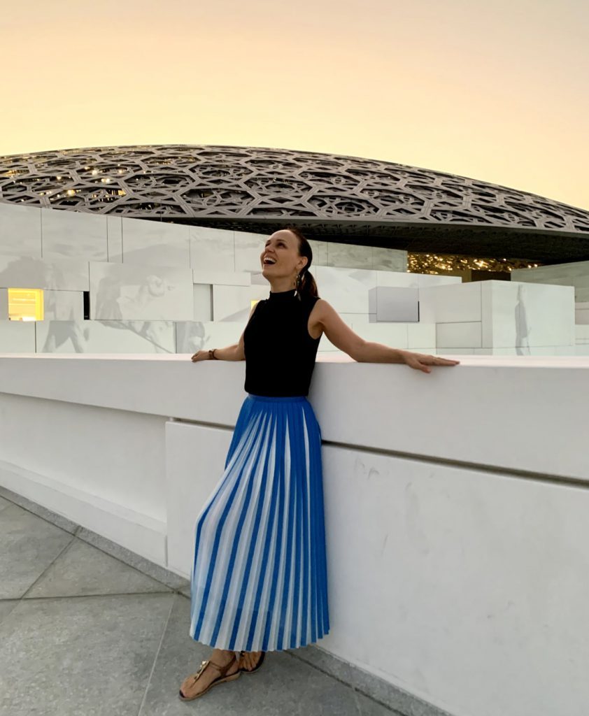 Dr. Natalia Wiechowski leaning against a balustrade at sun set.