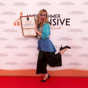 Dr. Natalia Wiechowski standing on a red carpet in front holding an award as top expert.